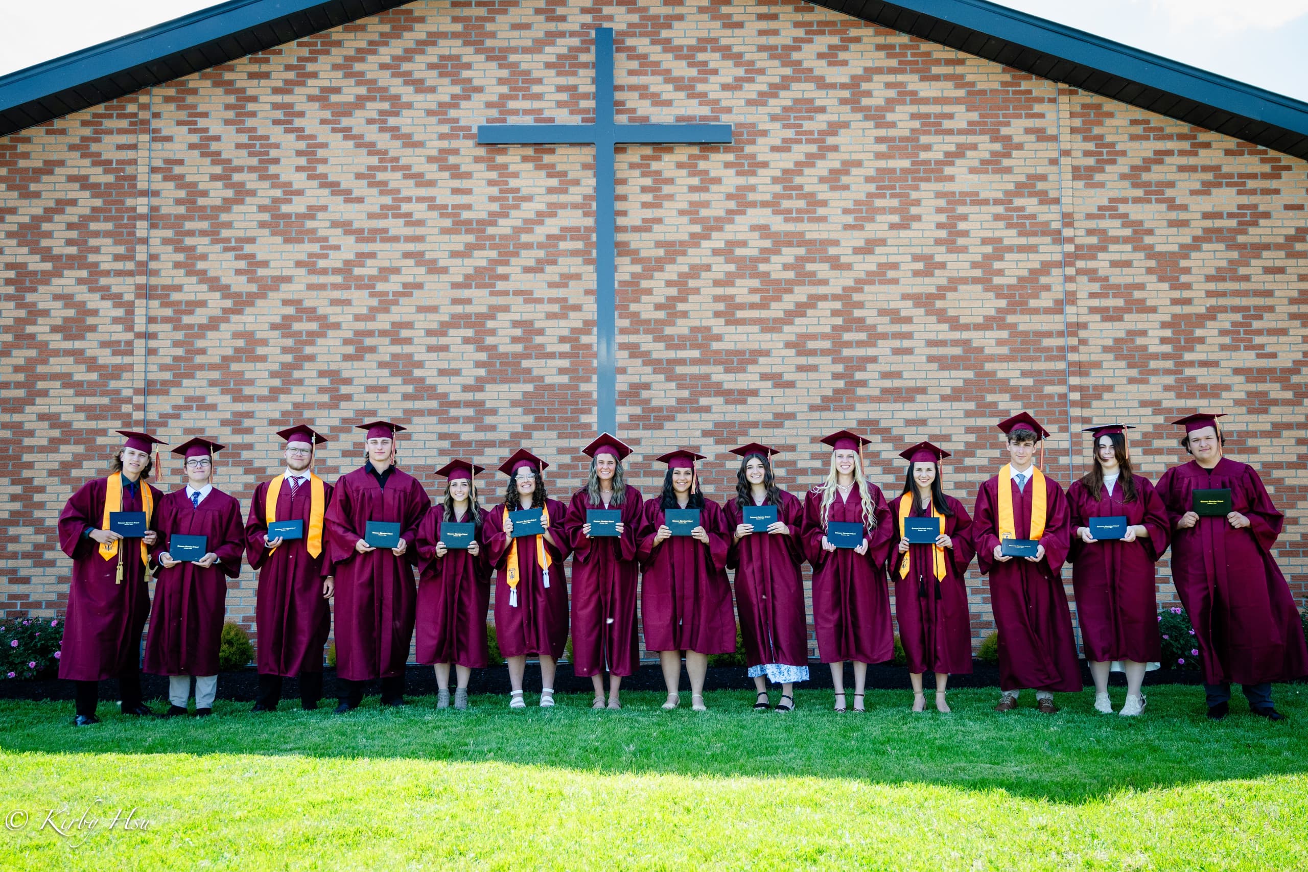 Graduating class on campus with cross